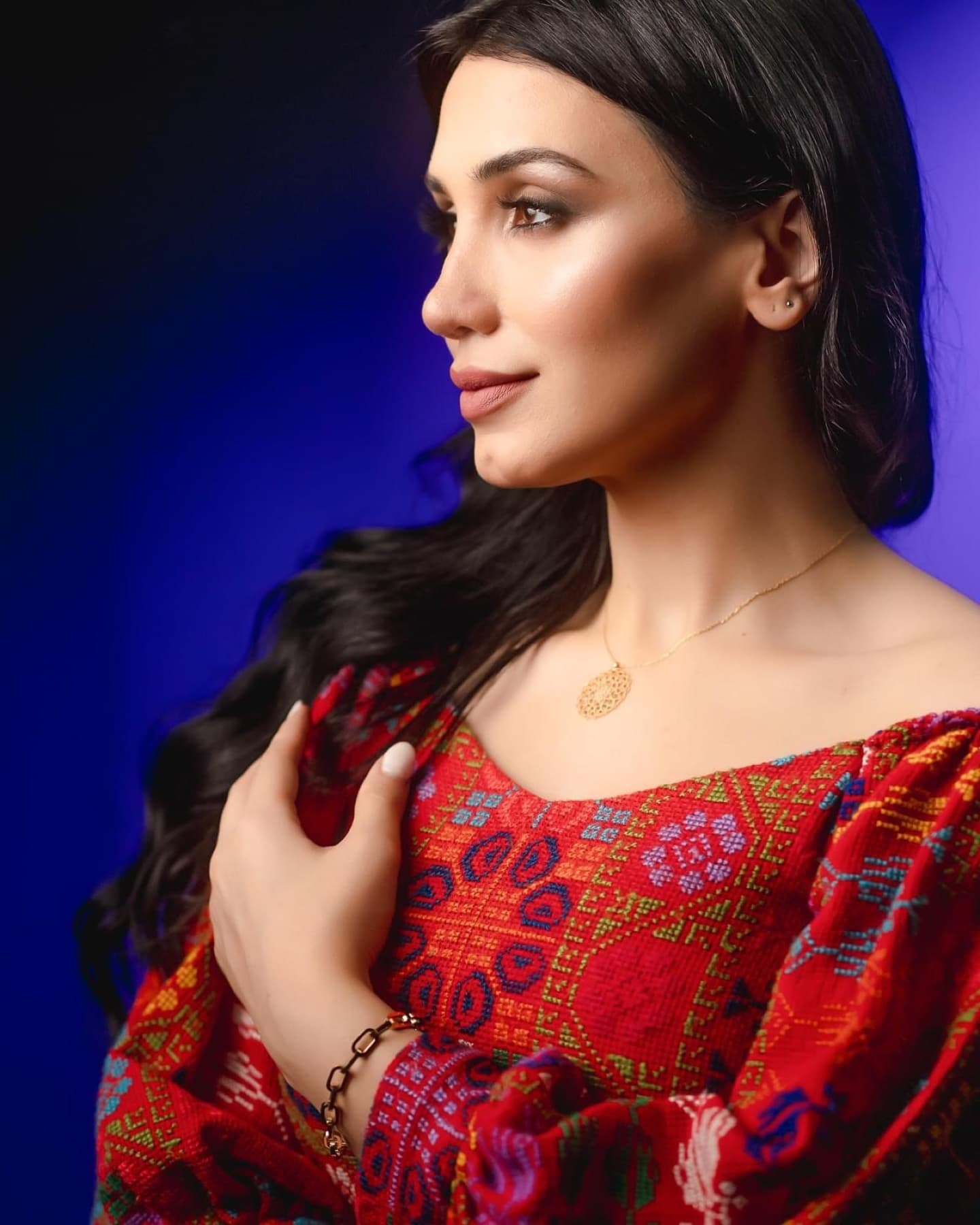 Studio portrait in embroidered red garment and jewelry