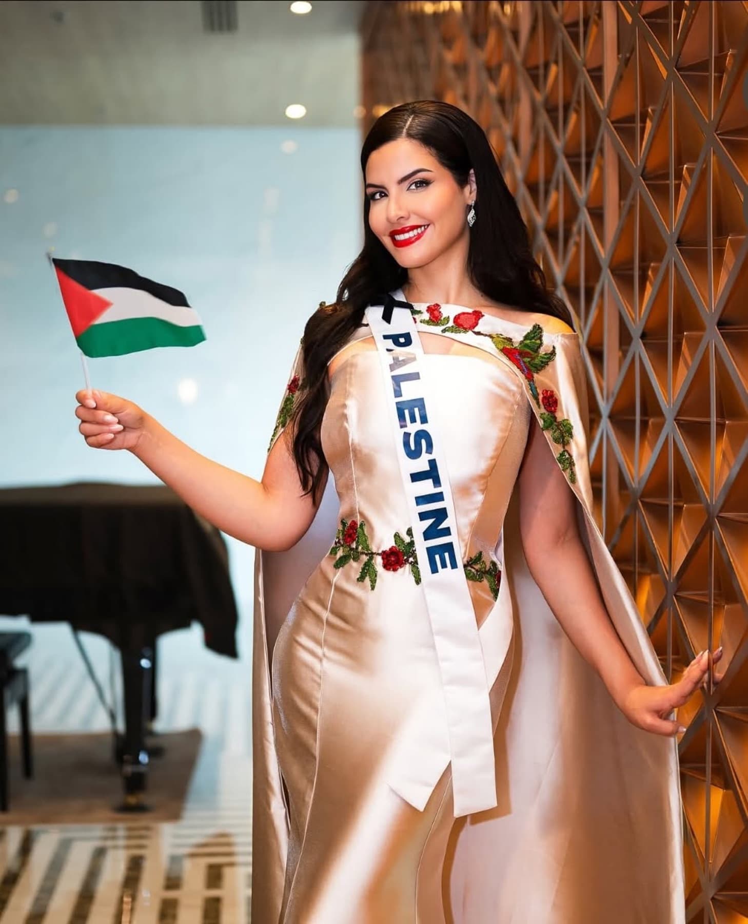 Nadeen Ayoub smiling in the embroidered Miss Palestine look