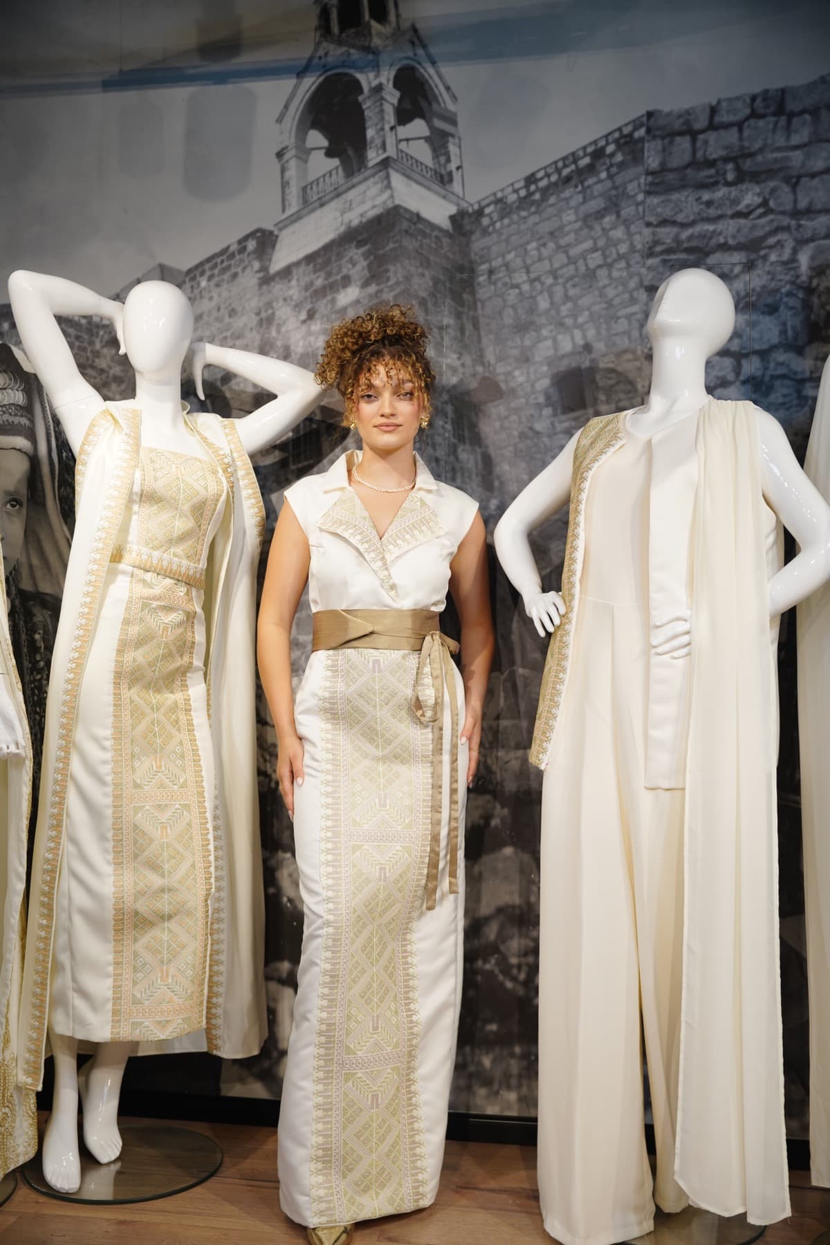 Bride standing between ivory embroidered garments