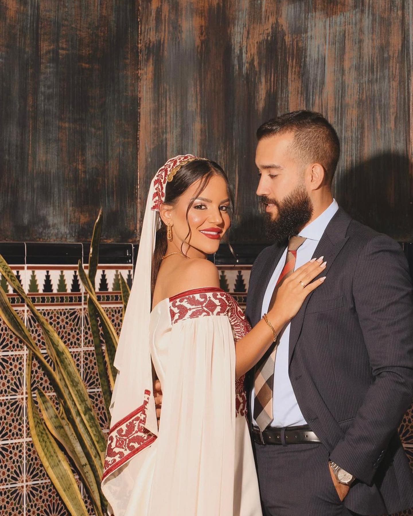 Bride and groom with red embroidered bridal veil