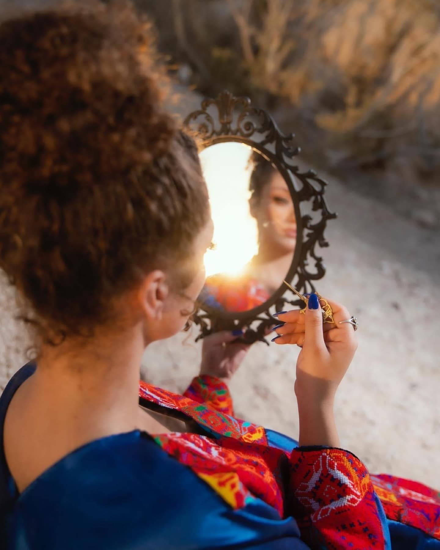 Mirror detail with embroidered garment and warm light
